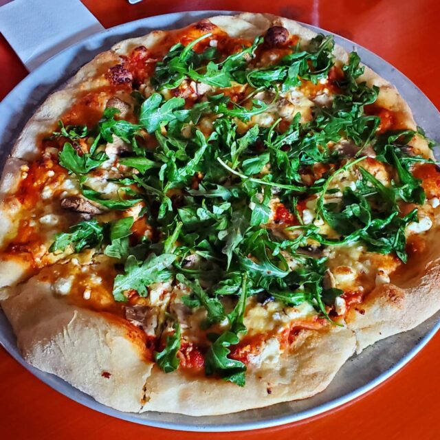 a pizza sitting on top of a plate of food