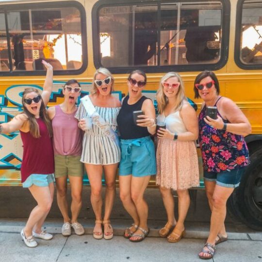 bachelorette group making silly faces by party bus