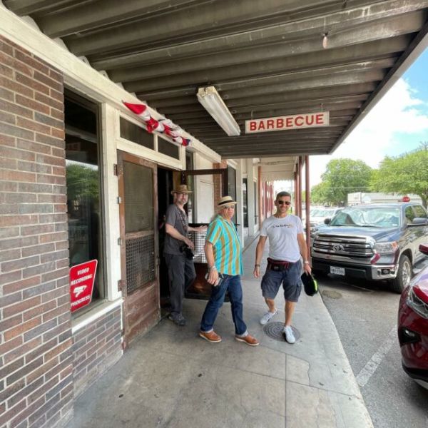 a man standing on a sidewalk in front of a building