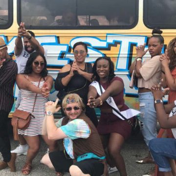 a group of people posing in front of a bus