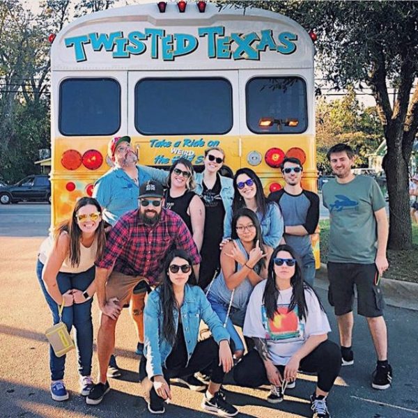 a group of people standing in front of a bus