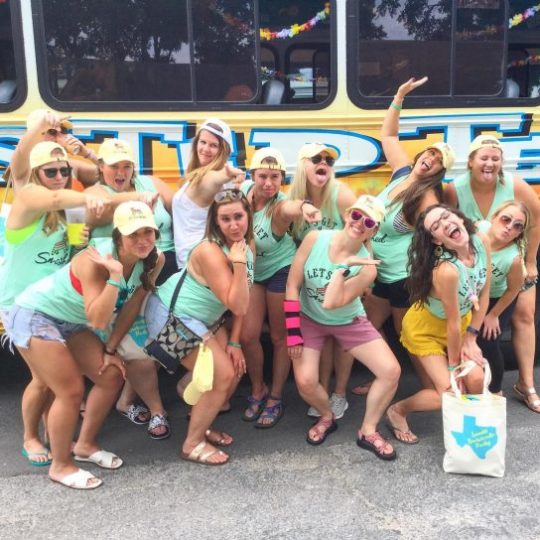 bachelorette group making funny poses by party bus
