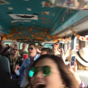 crowd shot of people enjoying concert on a bus