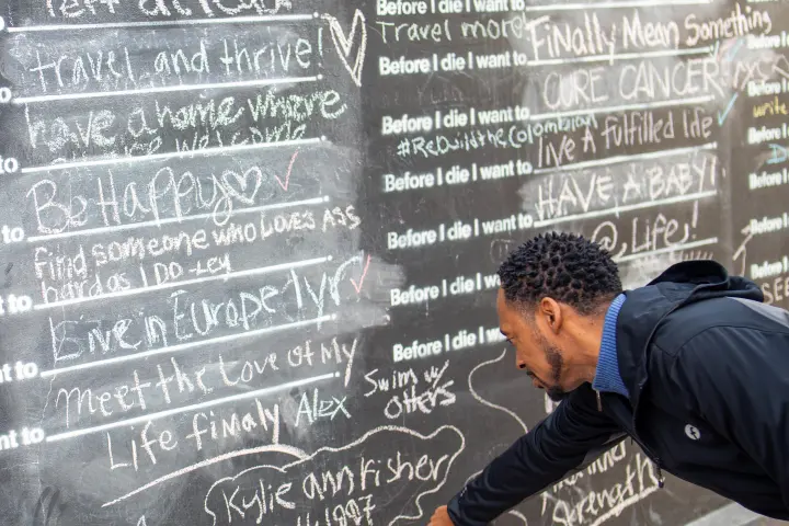 a man standing in front of a blackboard