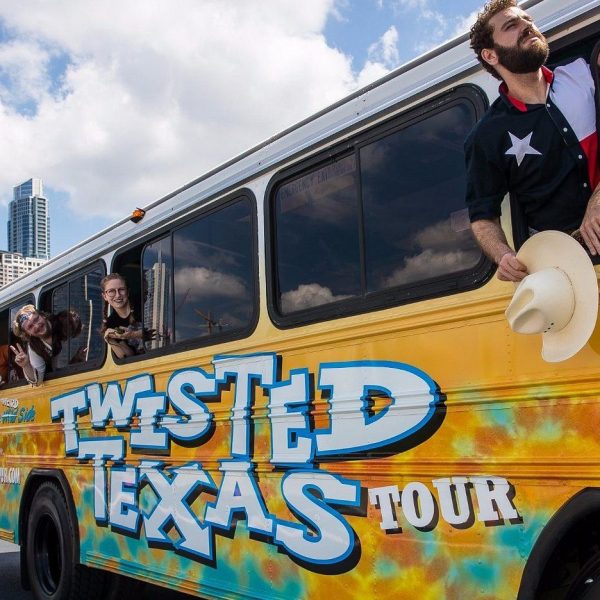 four people dressed in costumes leaning out party bus windows