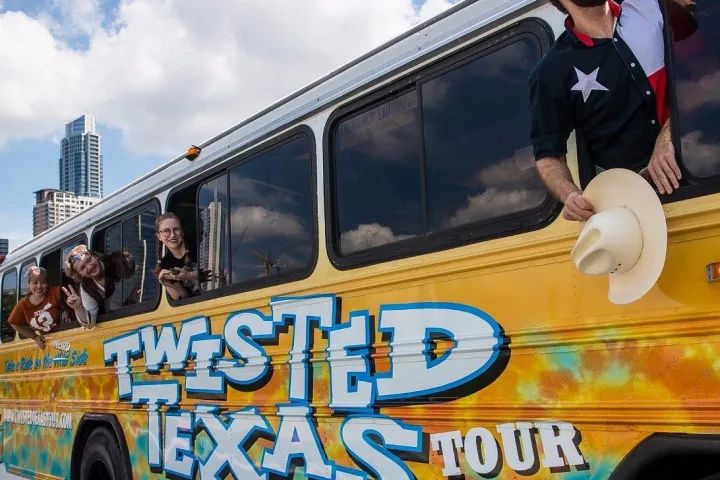 four people dressed in costumes leaning out party bus windows